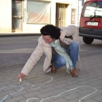 Eine Frau zeichnet einen Kreidefuß.